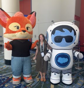 Emilie Lee, EVP of Global Analytics + Media Operations, standing next to Sales force Mascots at Salesforce CNX 2025