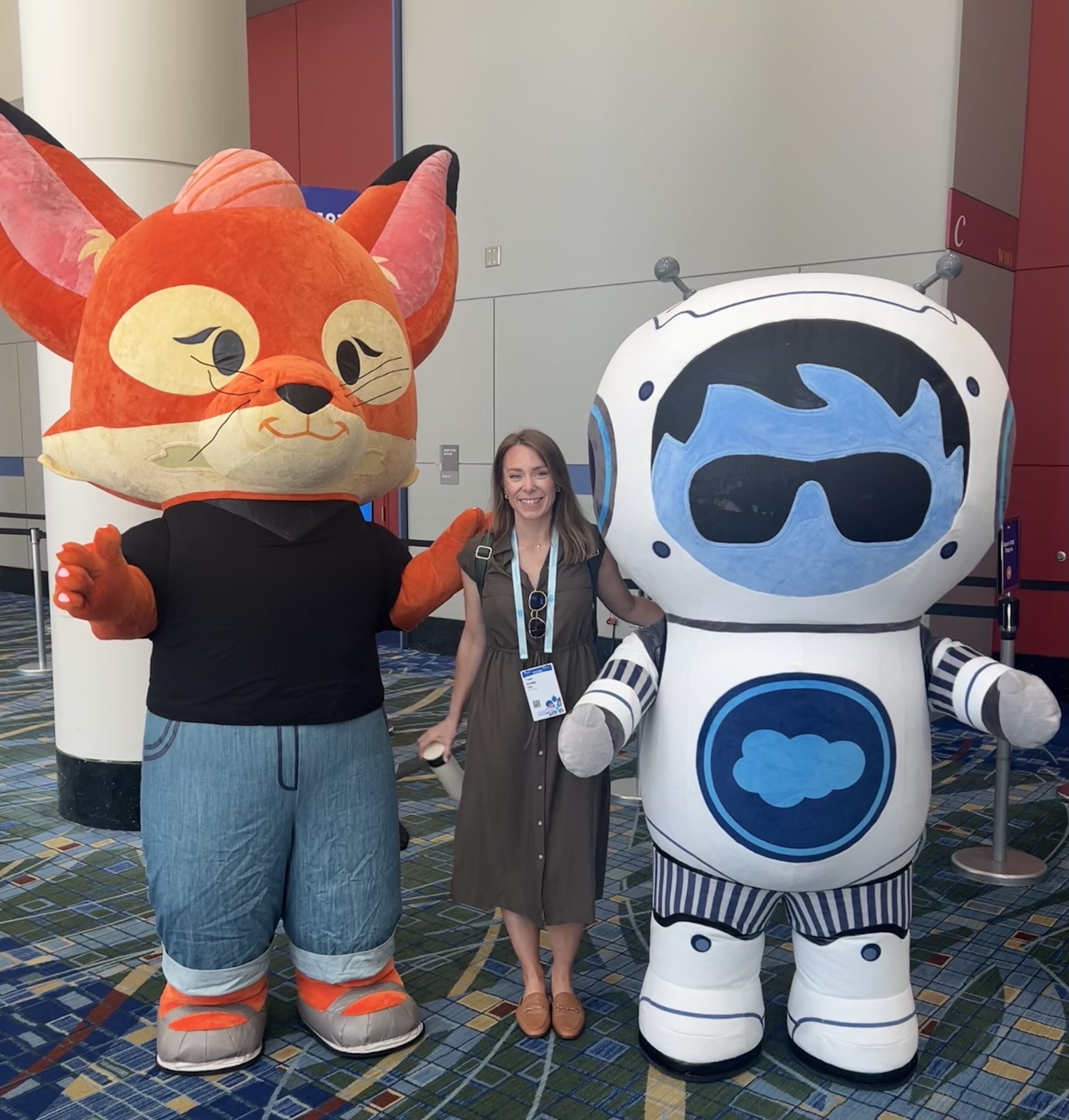 Emilie Lee, EVP of Global Analytics + Media Operations, standing next to Sales force Mascots at Salesforce CNX 2025